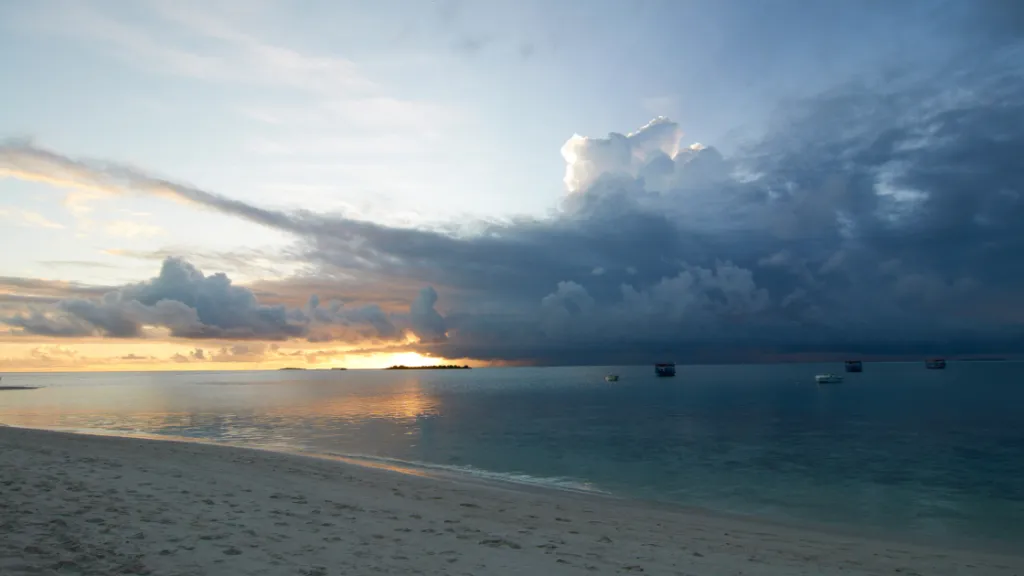 Malediven Regenzeit Wolken Dramatische Wolkentürme über der Lagune im warmen Licht des Sonnenuntergangs