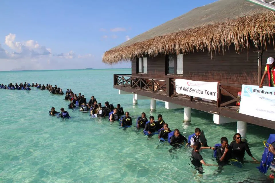 Lange Schlange wartender Taucher im Wasser vor der einzelnen Ausstiegstreppe