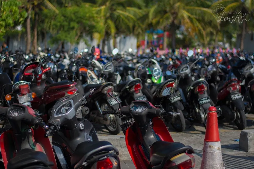 Dichter Verkehr mit Mopeds und Autos in einer Straße von Malé