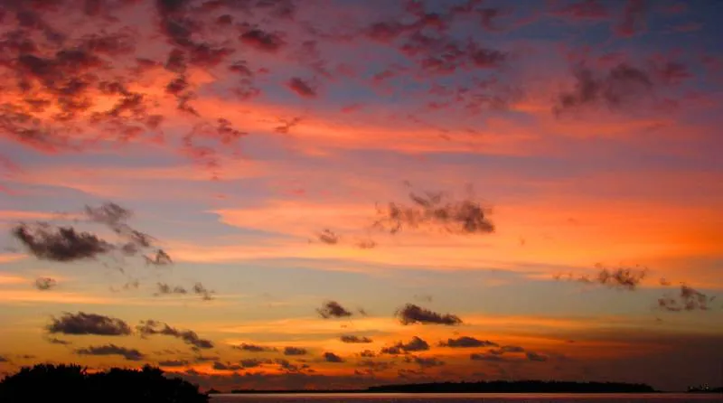 Dramatischer rot-violetter Abendhimmel über den Inseln am Horizont