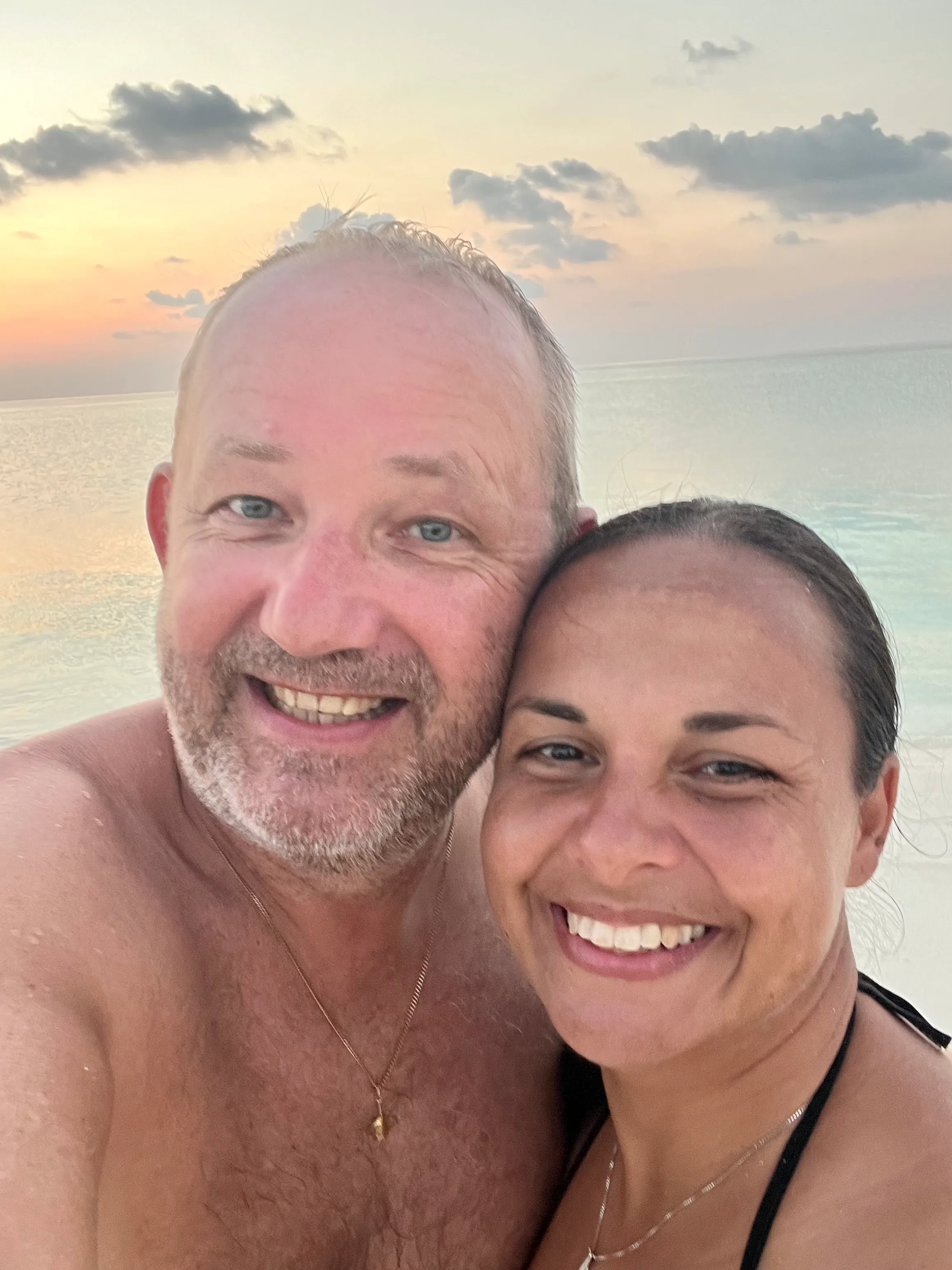 Yami und Toddy, die Inselnauten, lächelnd bei Sonnenuntergang auf den Malediven