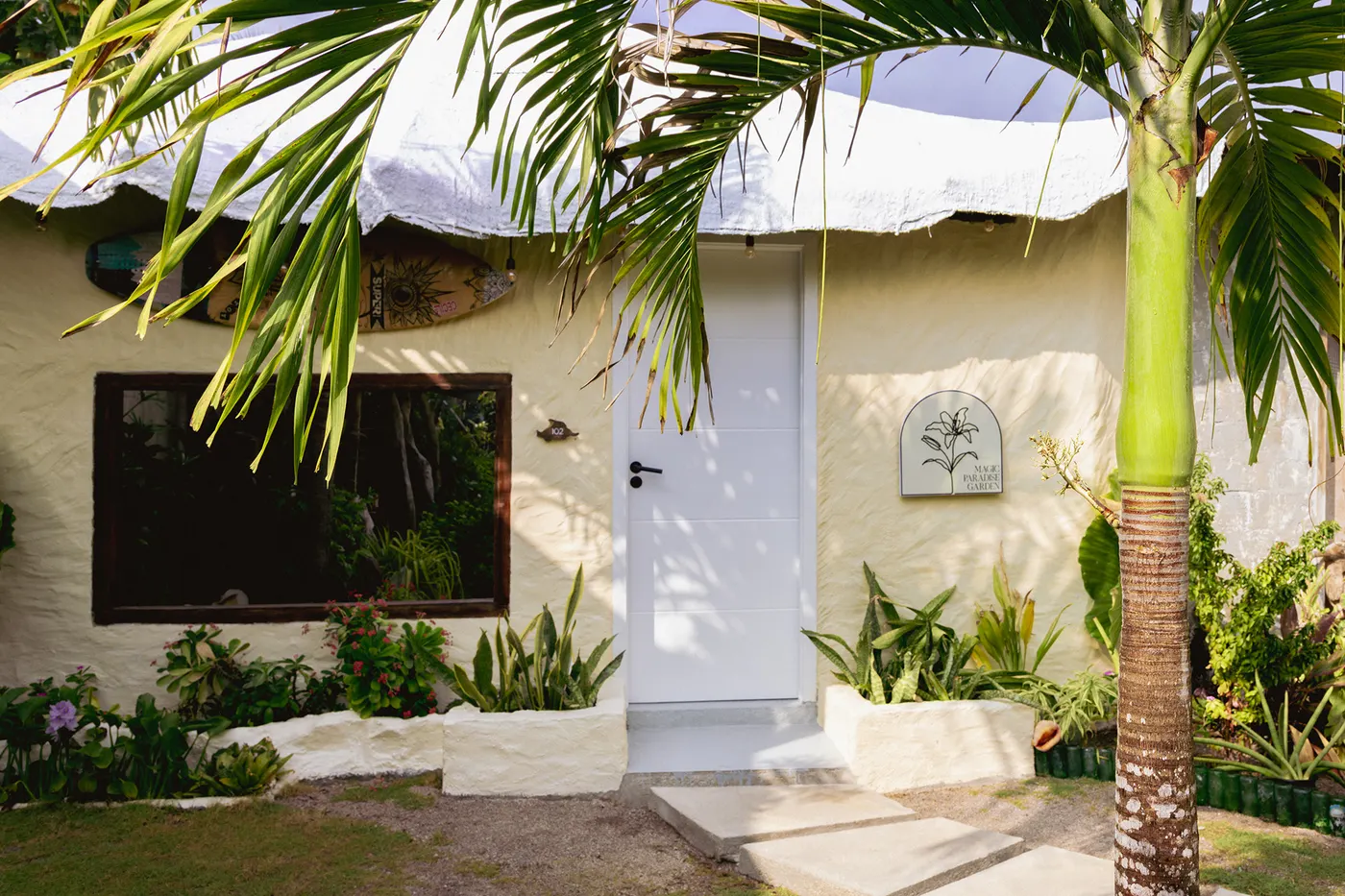 Eingang zum Homestay-Zimmer mit Palme und Gartenweg