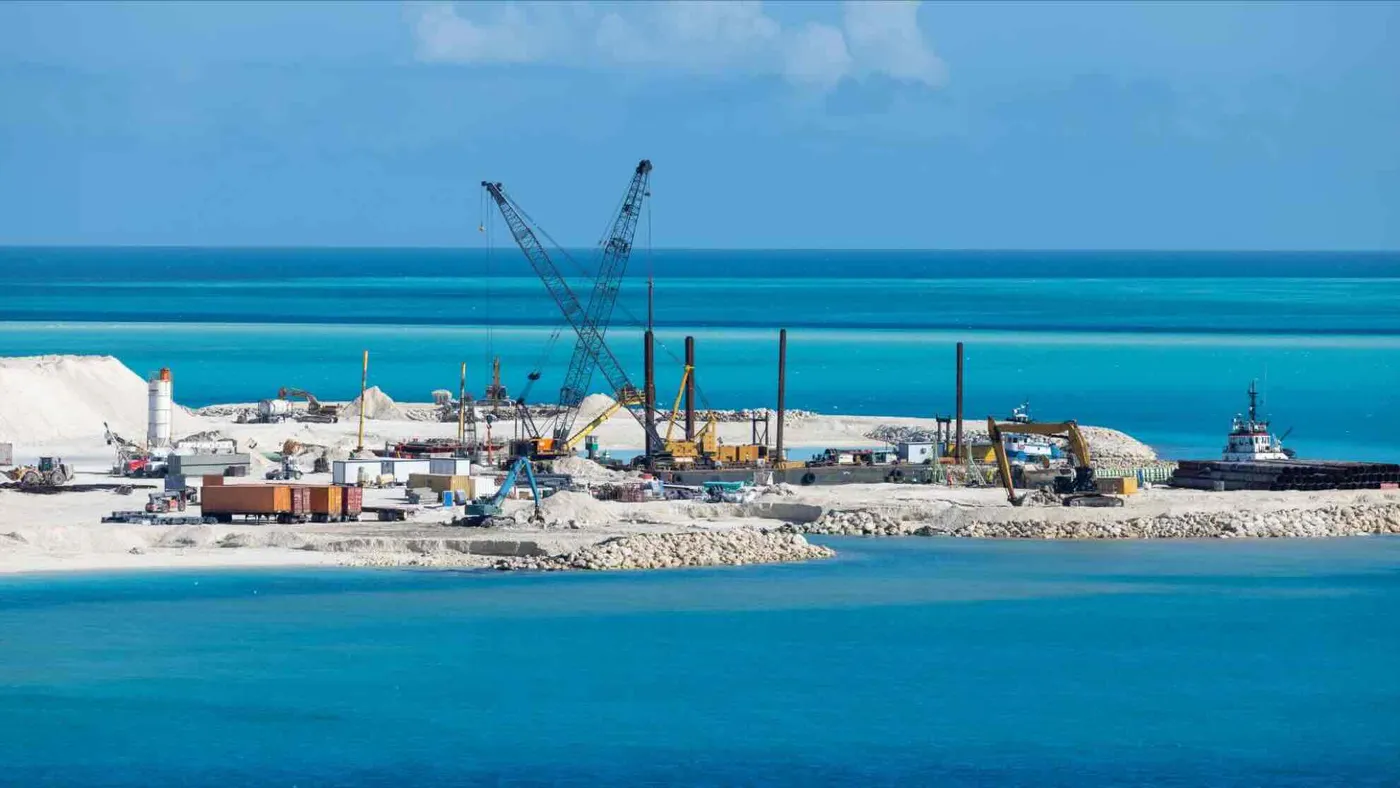 Baustelle einer künstlichen Insel auf den Malediven mit Kränen und Baggerschiffen beim Sandaufschütten